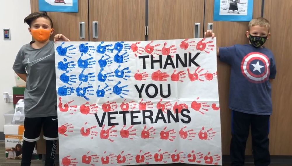 Students holding "Thank You Veterans" sign