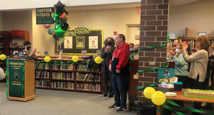 Mr. Pagel receiving recognition with balloons and people clapping