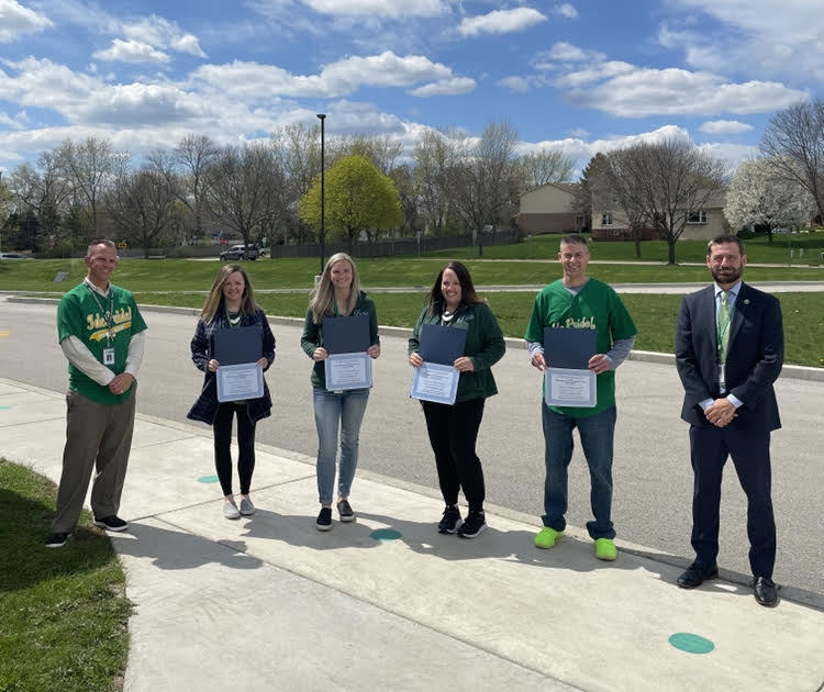 6 Ide staff members standing outside holding award certificates