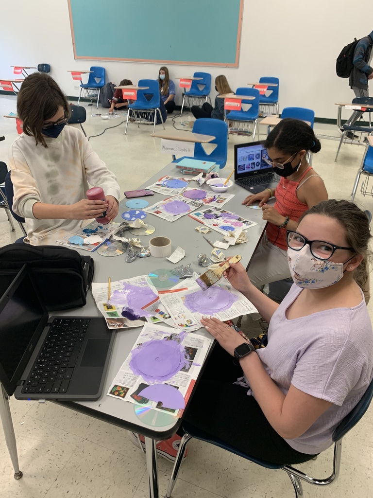 Students use different paints to create custom colors. This group created a beautiful spring purple!