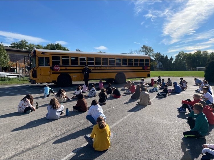 students sitting in front of bus
