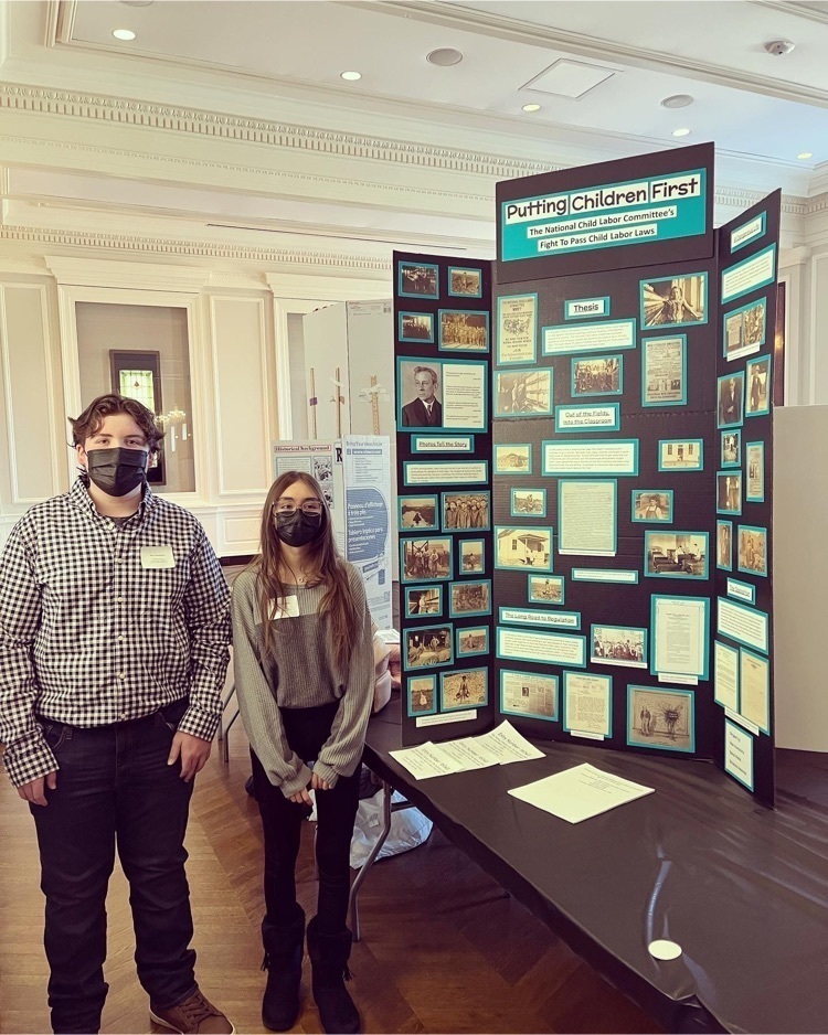 2 students with history project board