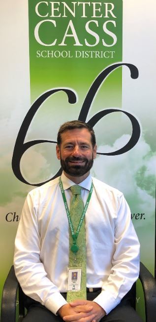 Dr. Andrew wise standing in front of center cass banner